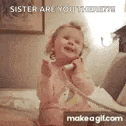 a little girl is sitting on a bed talking on a phone .