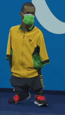 a man wearing a mask and a yellow jacket with the letter r on the front