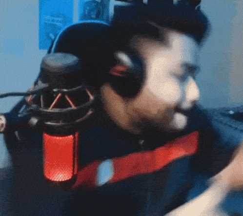 a man wearing headphones and a red microphone is dancing