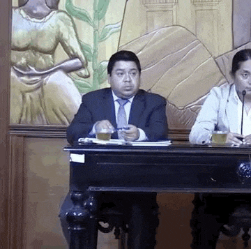 a man in a suit and tie is sitting at a table with a woman in a suit .