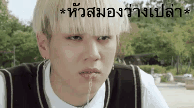 a young man with blonde hair is making a funny face with his mouth open in a foreign language .