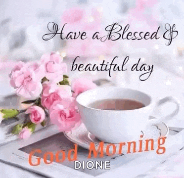 a cup of coffee and pink flowers are on a table with a good morning message .