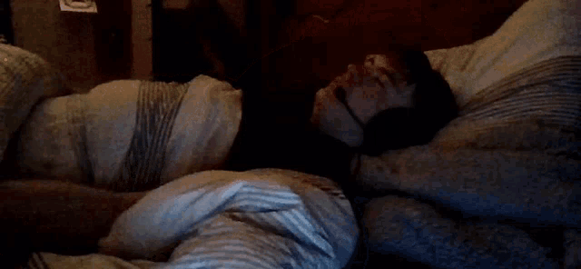 a person is laying on a bed with a white pillow