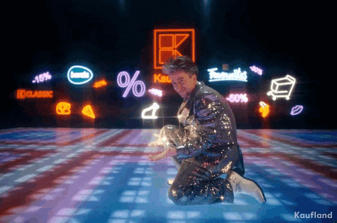a man in a sequined suit kneeling on a dance floor