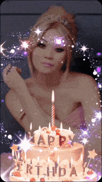 a woman is standing in front of a birthday cake with candles that says happy birthday