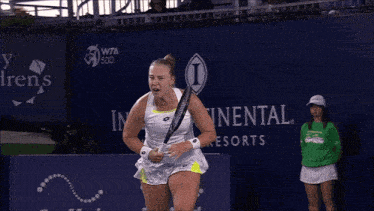 a tennis player is celebrating a win in front of a sign that says continental resorts