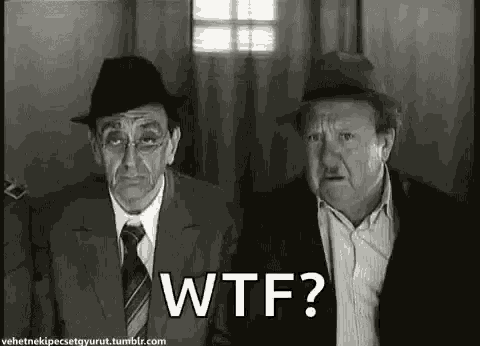 two men in suits and hats are sitting next to each other in a black and white photo .
