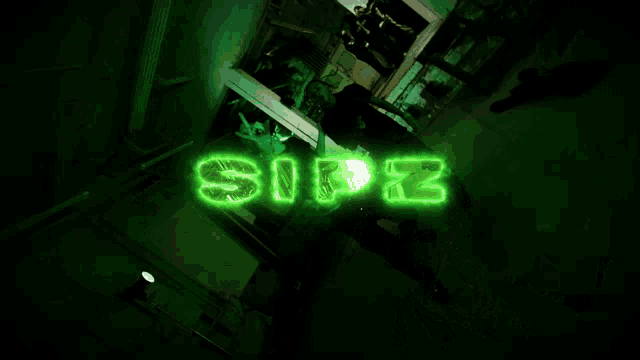 a group of people are dancing in a dark room with a green sign that says ' safe ' on it