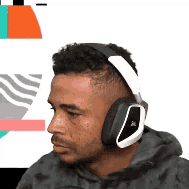 a man wearing a pair of corsair headphones looks at the camera