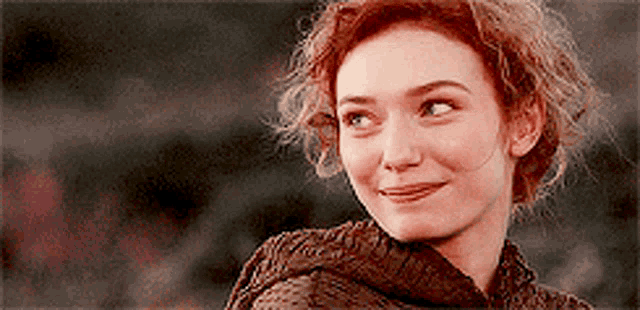 a close up of a woman 's face with a smile
