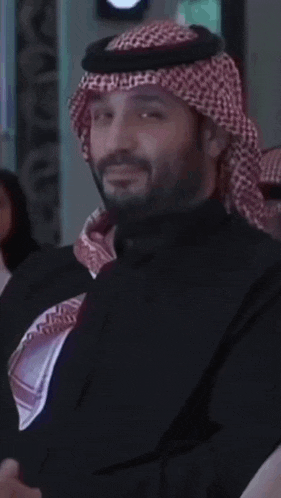 a man wearing a black shirt and a red and white head scarf