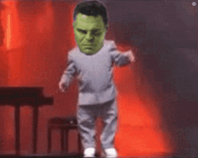 a man with a green head is dancing on a stage .