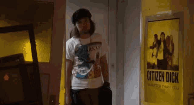 a man is standing in front of a poster for citizen dick