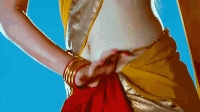 a close up of a woman 's belly with a yellow and red saree