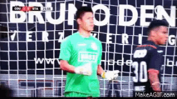 two soccer players are standing in front of a wall that says bruno den