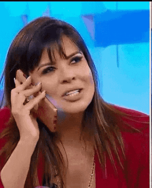 a woman is talking on a cell phone with a blue background .