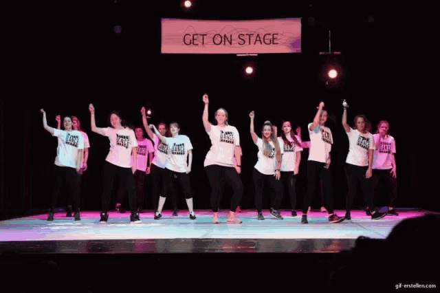 a group of young girls are performing on a stage with a sign that says get on stage