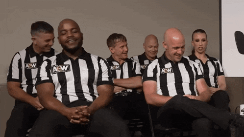 a group of men and women wearing aew shirts