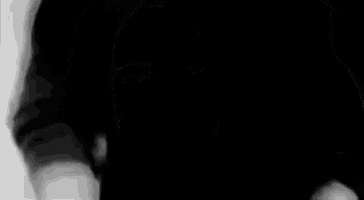 a man in a black shirt is standing in a black and white photo .