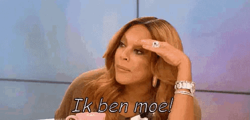 wendy williams is sitting at a table with a cup of coffee and says ik ben moe .