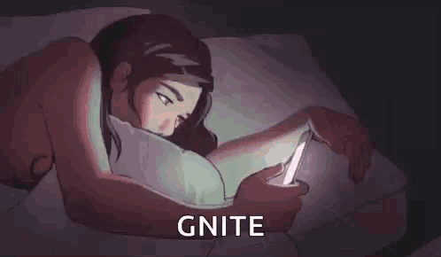 a woman is laying in bed looking at a cell phone .