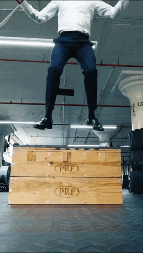 a man jumps over a prf wooden box