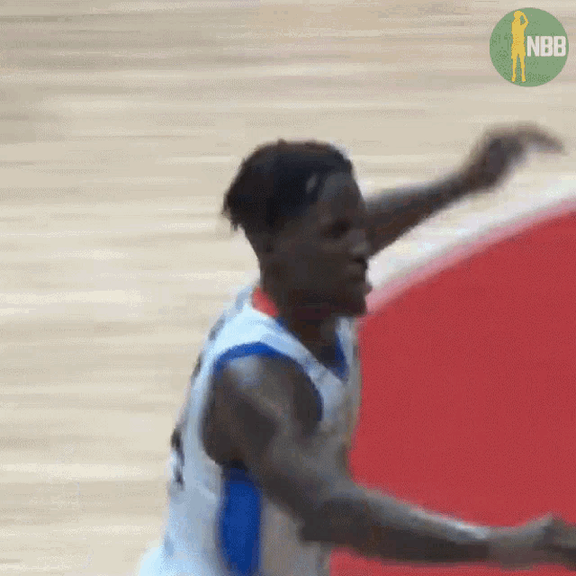 a basketball player is jumping in the air with a nbb logo behind him