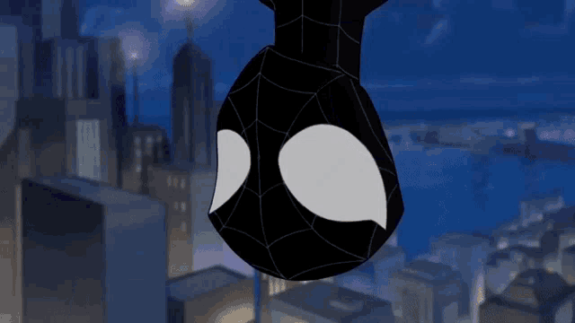 a spider man hanging upside down in a city