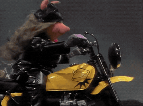 a pig is riding a yellow motorcycle with a star on the tank