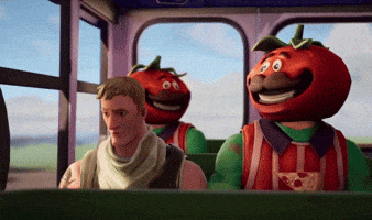 a man is sitting on a bus with a tomato head on his head