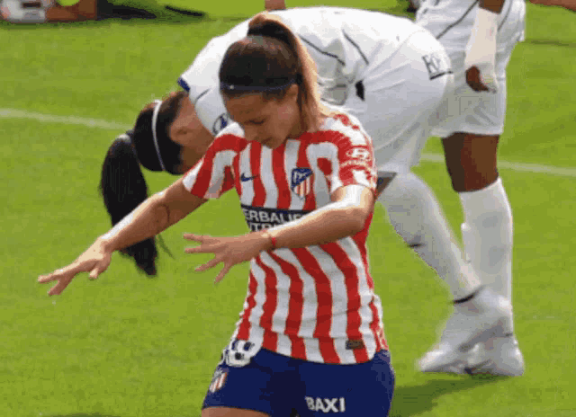 a female soccer player wearing a red and white striped shirt with the number 18 on it