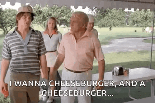 a group of men are standing next to each other on a golf course and one of them is talking about cheeseburger .