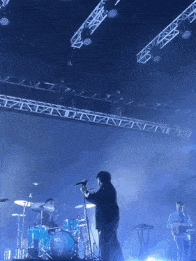 a man singing into a microphone on stage