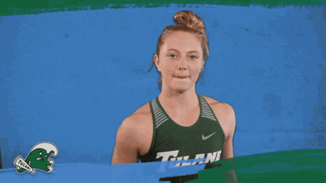 a woman flexes her muscles wearing a tank top that says titans