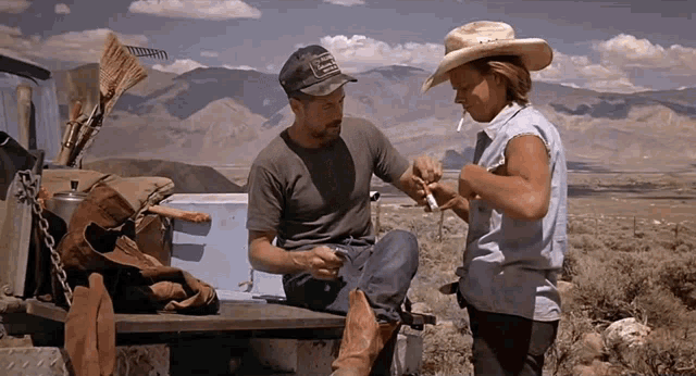 a man wearing a hat that says jeep on it sits next to a woman