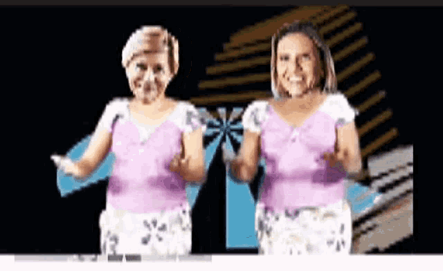 two women in pink shirts are dancing together in front of a black background