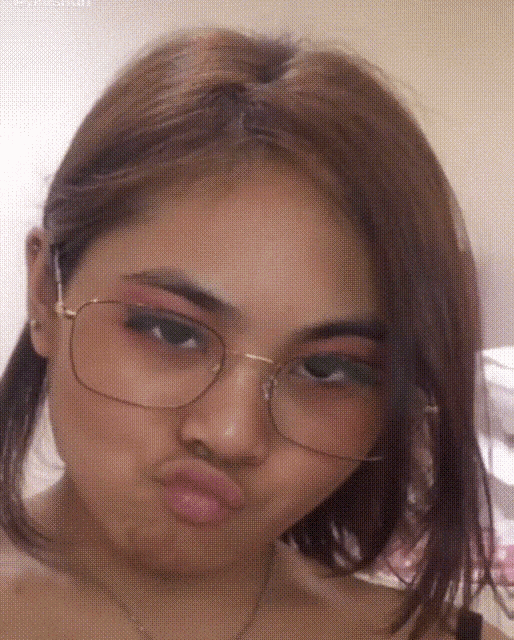 a woman wearing glasses makes a funny face