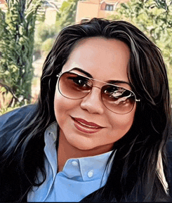 a woman wearing sunglasses and a blue shirt smiles