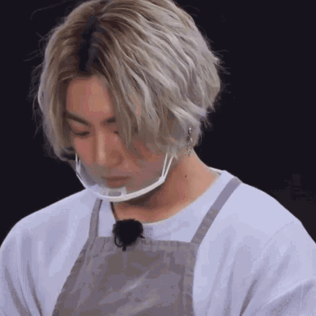 a close up of a person wearing a face mask and apron
