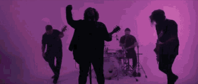 a group of people are standing next to each other in a purple room .