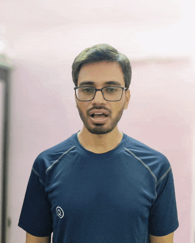 a man wearing glasses and a blue t-shirt with a circle on it