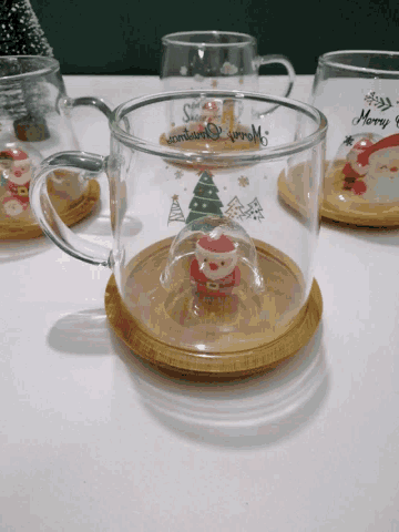 a glass cup with a santa claus figurine in it and the words merry christmas on it