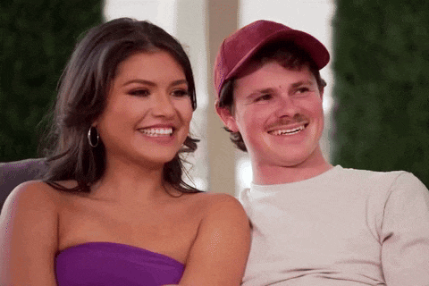a man and a woman are sitting next to each other and smiling for the camera