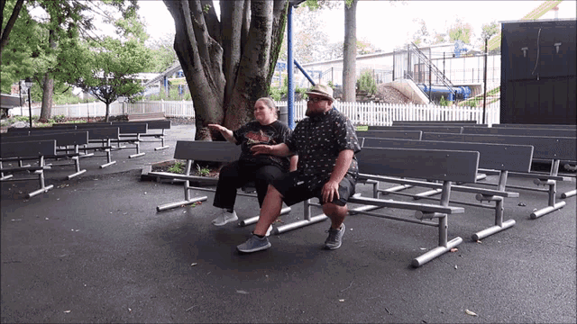 a man and a woman sit on a park bench