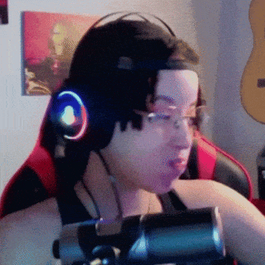 a man wearing headphones and glasses is sitting in front of a microphone