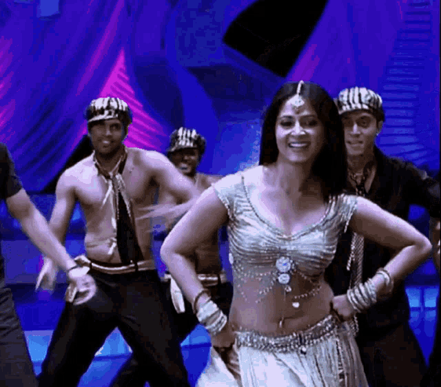 a group of men and a woman are dancing on a stage ..