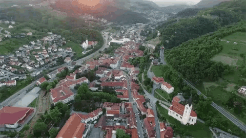 an aerial view of a small town surrounded by mountains and trees