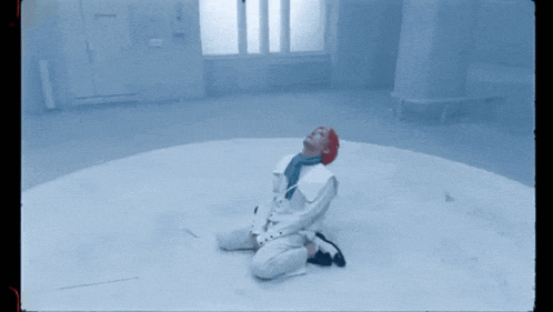 a person with red hair is kneeling down in a room