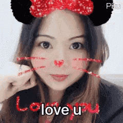 a woman is wearing a mickey mouse headband and says i love you .