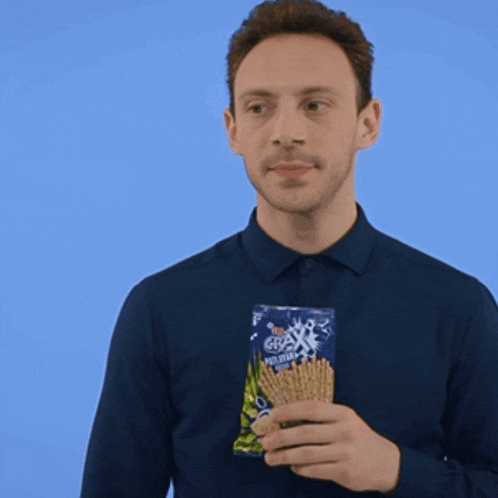a man is holding a bag of graham crackers in his hand